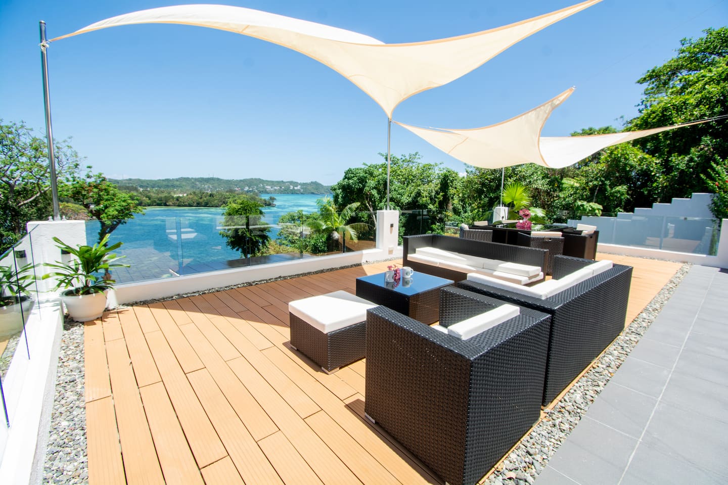 Rooftop lounge under sail shades overlooking the bay