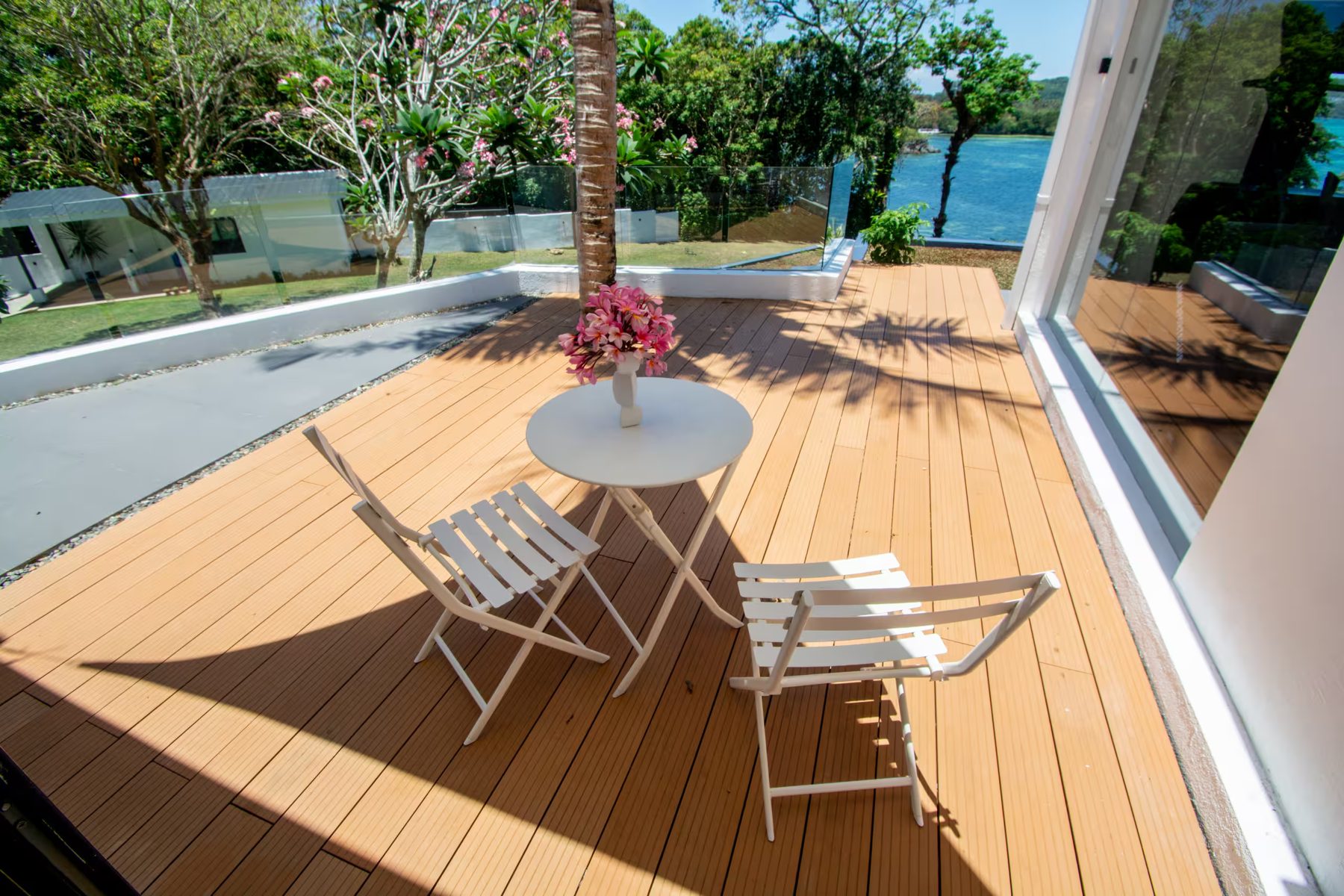 Garden Suite private terrace with bistro table, frangipani and sea view